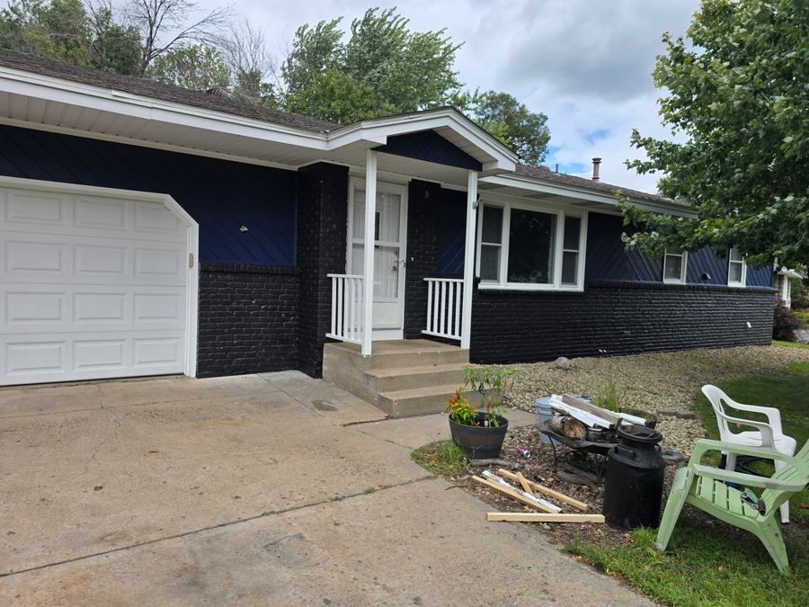 House exterior after professional painting with navy blue and white trim
